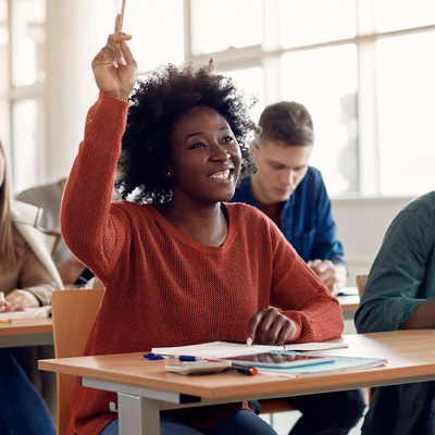Student raising hand engaged in class