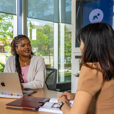 Student and faculty having a discussion.